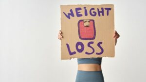 woman holding weight loss cardboard sign