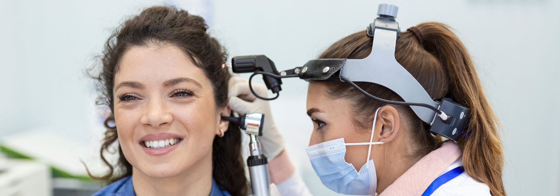 Pharmacist performing ear examination for blocked ear