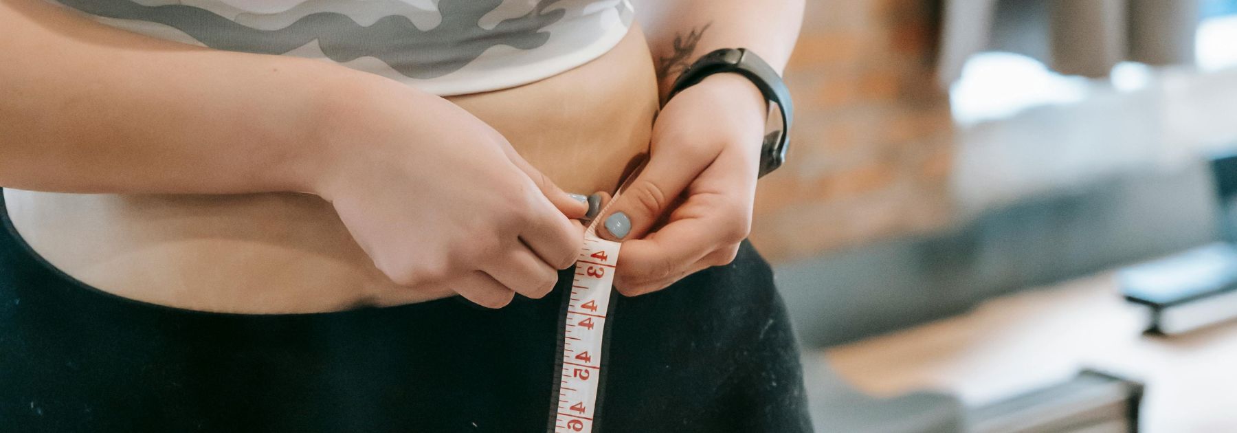 woman measuring waist size after taking mounjaro